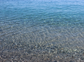 Beautiful crystalline transparent sea water and sun reflections