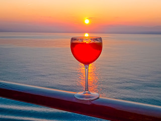 Wall Mural - Vue d'un cocktail sur le pont d'un navire de croisière au coucher de soleil dans le sillage du navire de croisière. Vue depuis la poupe du navire.	