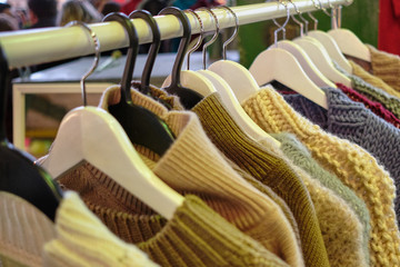 Stand with hangers of fashionable sweaters.