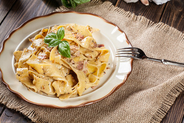 Wall Mural - Pappardelle pasta with prosciutto and cheese sauce on a plate