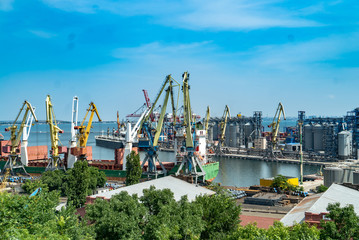 Container cargo freight ship with working crane bridge in shipyard at daytime. Logistic import export background at sun light.