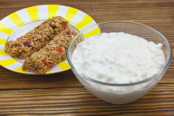 Tasty fresh grained cottage cheese on a plate on  wooden table