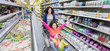 © Robert Daly/Caia Image - Mother pushing playful daughter in shopping cart in supermarket aisle