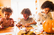 © Sam Edwards/Caia Image - Brother and sisters making autumn crafts at table