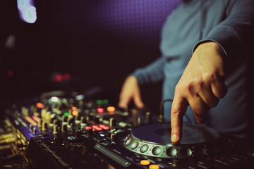  dj is mixing tracks at party in night club. disc jockey playing music on the modern turntable close up. 