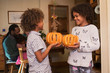 © Sam Edwards/Caia Image - Happy brother and sister holding carved pumpkins