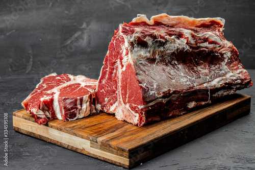 Fotografía Raw T-bone steak cooking on stone table.