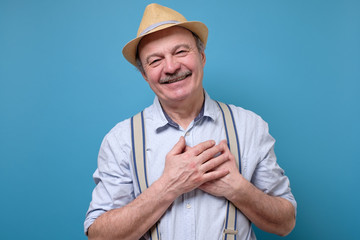 Wall Mural - senior man posing in studio smiling joyfully, being pleased with compliment