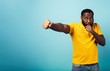 Angry man attacks with a punch something. Blue background