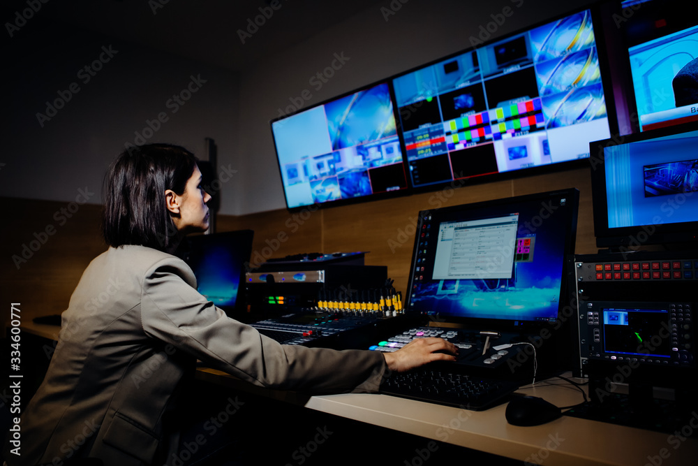 Female TV director control editing room in television studio.Operating vision mixer console equipment in a broadcast panel gallery.Realtime graphic engineer editor.Breaking news headline.Live stream - obrazy, fototapety, plakaty 