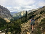 Fototapeta Las - Hiking the rocky terrain of the Crypt Lake Trail, a steep ascent to Crypt Lake including walking a long the very edge of a mountain.  The hike is in Waterton Lakes National Park in Alberta, Canada