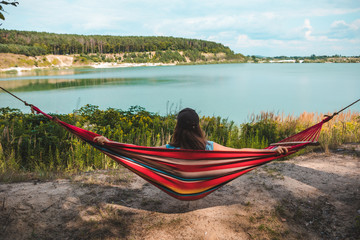 Wall Mural - woman laying on hammock enjoying the view of summer lake