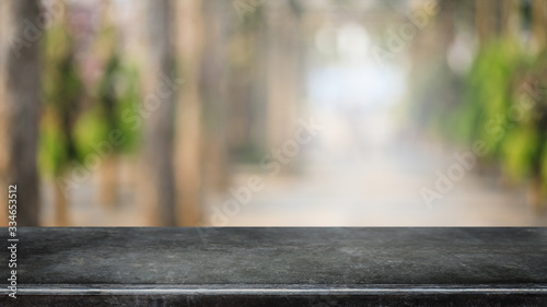 Cuadros en Lienzo Empty black marble stone table top and blurred green tree and vegetable in greenhouse of agricultural farms