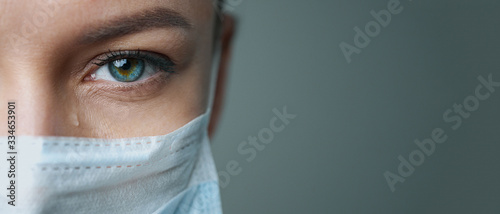 Fotomural A female doctor therapist in a white robe, mask and gloves