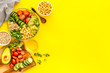 Healthy salad bowl with quinoa, avocado and chickpeas on yellow background top-down copy space