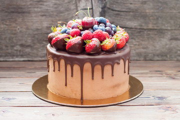 Wall Mural - Chocolate cake with melted dark chocolate and assorted fresh summer berries.