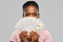 Finance, Currency And People Concept - African American Young Woman Holding Hundreds Of Dollar Money Banknotes Over Grey Background