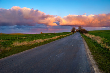 Wall Mural - beautiful, colorful clouds after the storm over the asphalt road