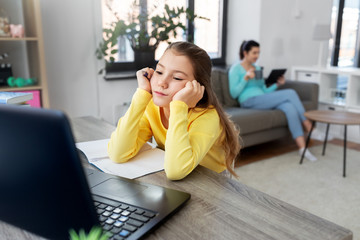 children, education and distant learning concept - bored student girl with laptop computer and noteb