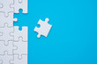 © pla2na - The last piece of jigsaw puzzle to complete task on blue background. Business strategy teamwork, problem solving concept. Teamwork is collaborative effort of team to achieve goal or complete mission.