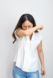 Asian woman cough or snezzing in arm prevention. Concept of Coronavirus COVID-19 reducing of risk of spreading the infection by covering nose and mouth when coughing and sneezing flexed elbow.