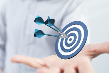 Poster - hand holding a target with darts hitting the center over white background. Concept of .
