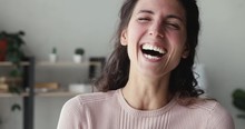 Cheerful Happy Young Adult Woman Laughing Out Loud Looking At Camera Standing Alone At Home Office. Smiling Funny Millennial Casual Lady Having Fun Bursting Into Laughter Indoors. Close Up Portrait.
