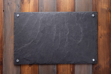 Wall Mural - black slate stone at wooden background