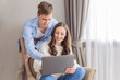© Marharyta Manukha - Cheerful couple looking at laptop computer, together on day and weekend off at home. Choose film, building family financial plan, meal planning for healthy style, wedding ideas, ordering gifts, online