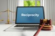 Reciprocity – Law, Judgment, Web. Laptop in the office with term on the screen. Hammer, Libra, Lawyer.