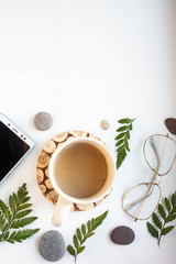 Wall Mural - phone mockup with coffee and leaves on white table