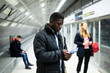 © JackF - African American man with phone at underground station