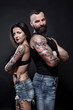 © alex.pin - coppia di ragazzi tatuati, che mostrano i loro tatuaggi e i loro muscoli, isolati su sfondo nero