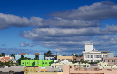 Fototapete - A bright green building in midst of colorful skyline in San Juan under Blue Dusk