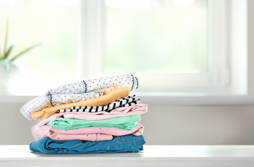 Wall Mural - Stack of cotton colorful clothes,folded clothing on table empty space.