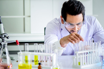 Wall Mural - attractive happiness scientist man lab technician assistant analyzing sample in test tube at laborat