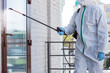 © master1305 - Coronavirus Pandemic. A disinfector in a protective suit and mask sprays disinfectants in house or office. Protection agsinst COVID-19 disease. Prevention of spreding pneumonia virus with surfaces.