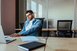 © LIGHTFIELD STUDIOS - Selective focus of thoughtful IT worker at table in coworking space