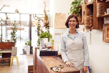 Sticker - Portrait Of Smiling Female Sales Assistant Standing Behind Sales Desk Of Florists Store