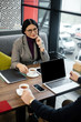 © LIGHTFIELD STUDIOS - selective focus of smiling asian businesswoman talking with businessman in cafe