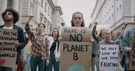 Wall Mural - Young woman holding poster with There is no planet B. Group of protestors making a protest about global warming and plastic pollution.
