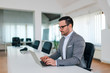 © bnenin - Portrait of a handsome businessman working on laptop.