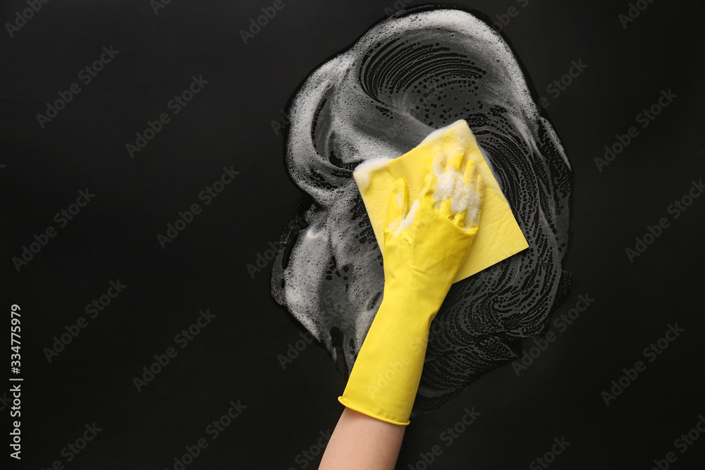 Hand of woman cleaning dark table