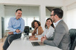 © bnenin - Positive business meeting. Smiling business people talking on a brainstorming meeting in bright office.