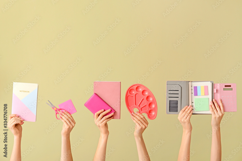 Many hands with school supplies on color background