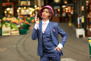 Wall Mural - a portrait of a young woman dressed in a tweed suit smoking a cigarette