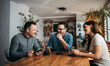 © bnenin - Portrait of a three business people on a break, sitting at table, talking and having tea and coffee.