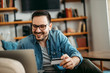 © bnenin - Close-up portrait of a smiling man shopping online with credit card.