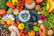 Background of healthy food. Fresh fruits, vegetables, meat and fish on table. Food to boost immunity. Choice healthy food or medicine pills concept. Top view, copy space