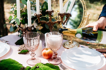 a beautiful table with decor and two glasses are poured into them champagne